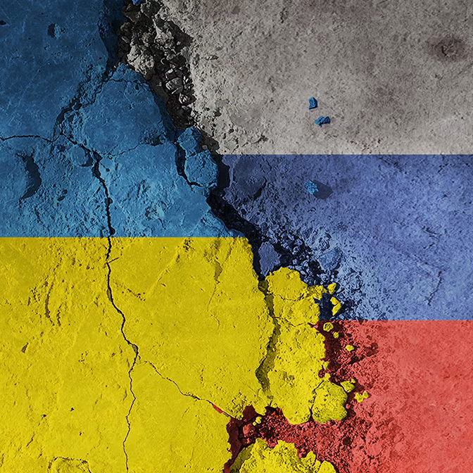 This image is a symbolic representation of the Russo-Ukrainian War, depicting the flags of Ukraine (left) and Russia (right) fractured on broken, cracked ground.
